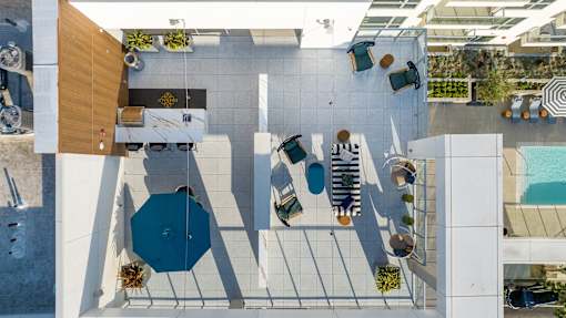 A top view of a poolside area with loungers and a table.