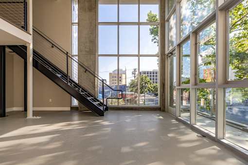 A large open space with a staircase and large windows.