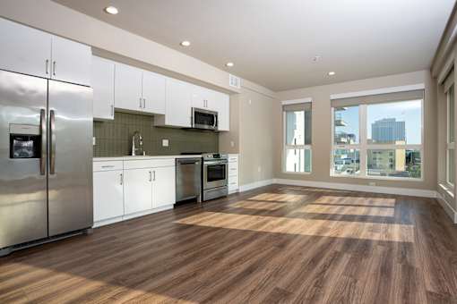A kitchen with white cabinets and a stainless steel refrigerator.