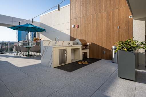 A patio with a table and chairs and a blue umbrella.