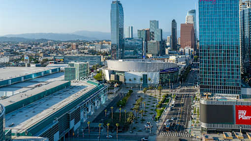 A cityscape with a large building in the foreground and a clear sky above.