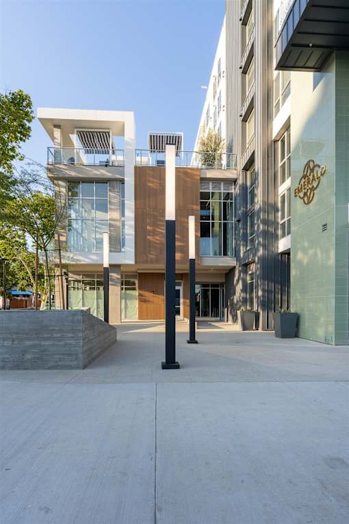 A modern building with a glass facade and a white balcony.