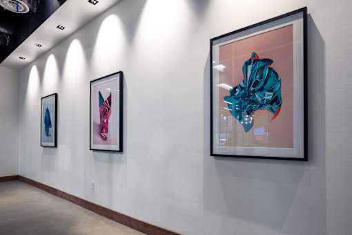 Three paintings are hanging on a wall.