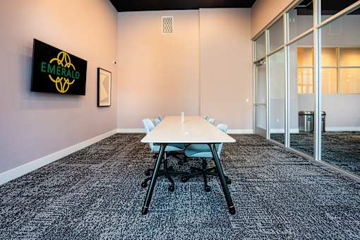 A conference room with a table and chairs and a sign that says Emerald.