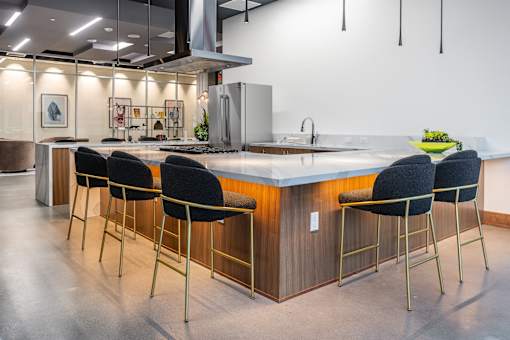 A modern kitchen with a long island and bar stools.