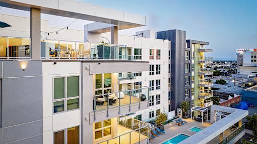 A modern apartment complex with a pool and balconies.