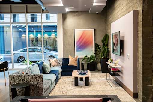 A modern living room with a large abstract painting on the wall.