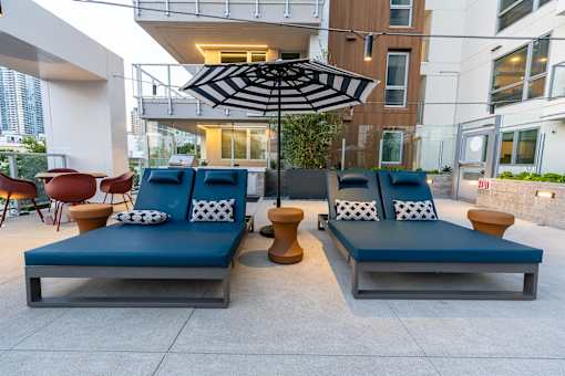 Two blue couches with white pillows are in front of a building.
