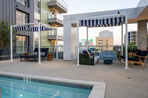 A pool area with a striped awning and a pool with a 20 meter marking.