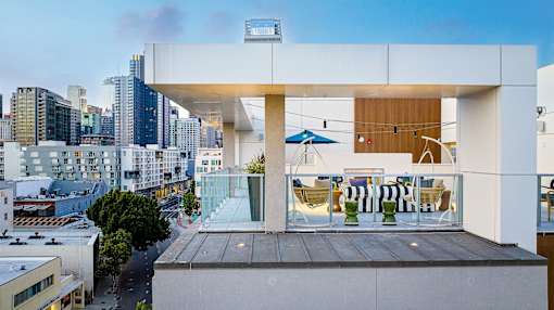 A modern building with a balcony overlooking a cityscape.