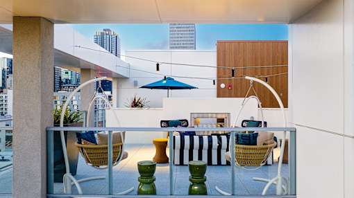 A patio with a table and chairs overlooking a city.