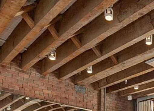 A wooden beam ceiling with lights on it.