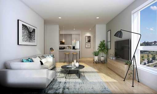 A modern living room with a white sofa, a coffee table, and a large window.