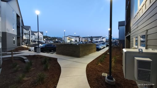 a view of a city street at night with buildings and a parking lot