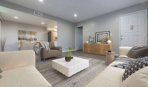 A living room with a white couch, a coffee table, and a painting on the wall.