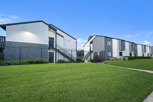 A row of modern houses with white walls and dark roofs.