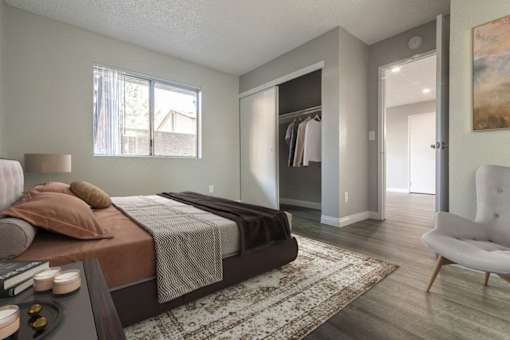 A bedroom with a large bed and a chair.