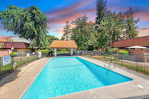 a swimming pool with a fence and a house with a pool