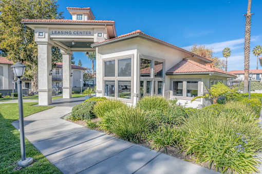 A leasing center is surrounded by green plants and trees.