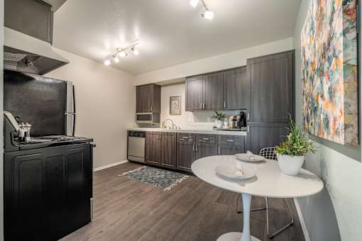 a kitchen with black appliances and a white table