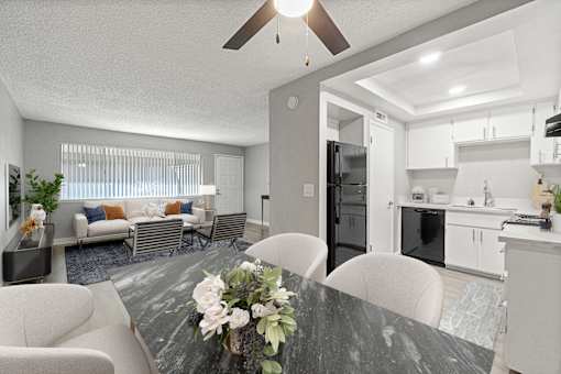 A modern kitchen with a dining table set in the middle.