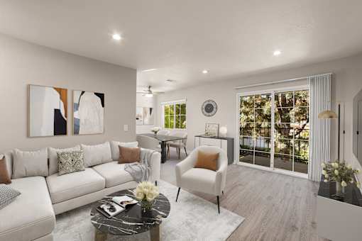 A modern living room with a white sofa, a coffee table, and a large window.