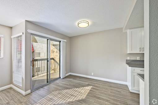 A room with a sliding glass door leading to a balcony.