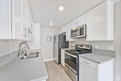A kitchen with white cabinets and stainless steel appliances.