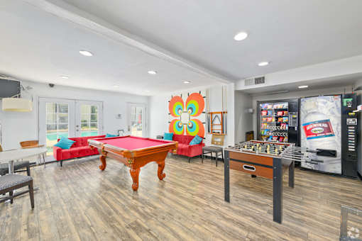 A room with a pool table and a pinball machine.