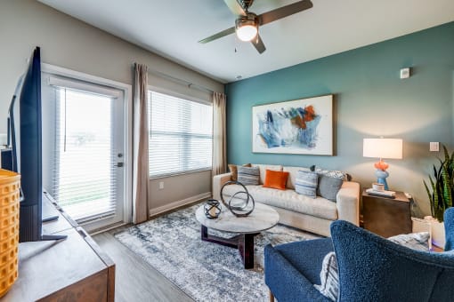 a living room with a couch and a ceiling fan