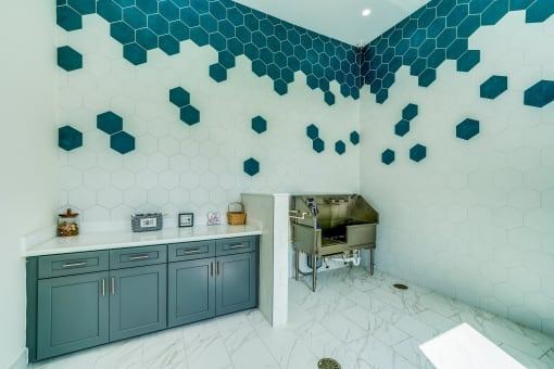 a kitchen with blue cabinets and tile walls and a grill