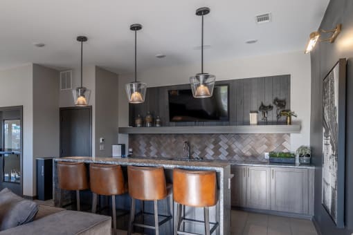a bar with four stools in a living room with a television