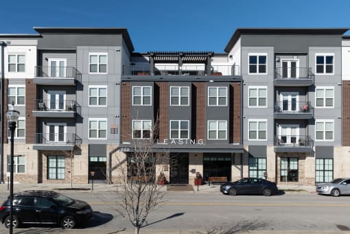 an apartment building on the corner of a street with cars
