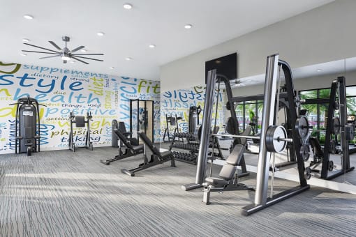 a gym with exercise equipment and a wall covered in graffiti