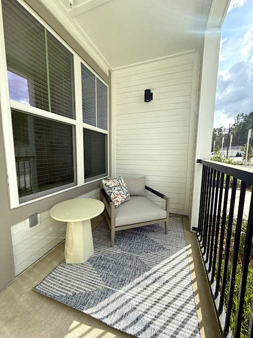 A small balcony with a white table and a sofa.