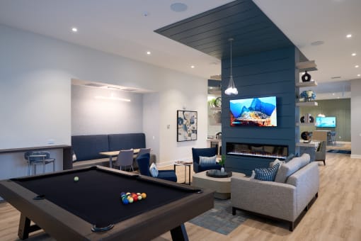 a living room with a pool table and a tv