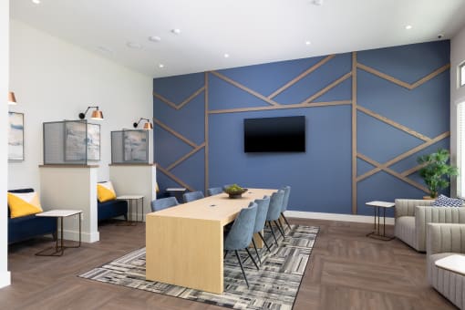 a conference room with a blue accent wall and a wooden table