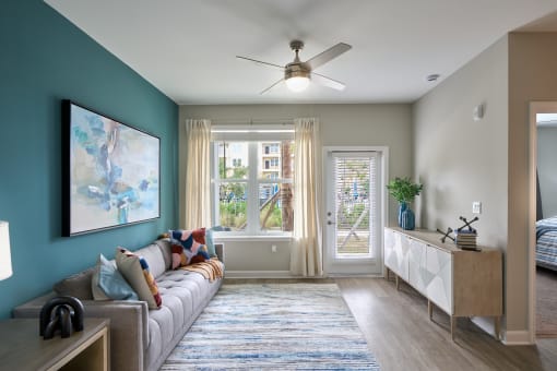 a living room with a couch and a ceiling fan