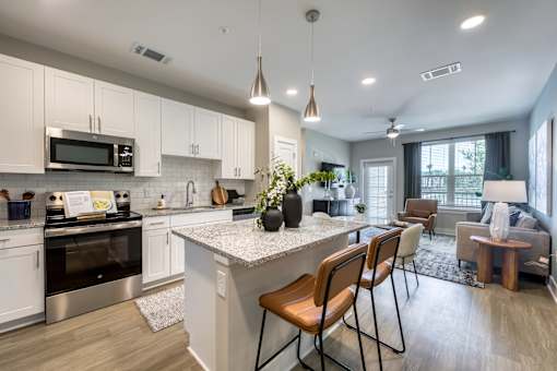 A modern kitchen with white cabinets and a large island.