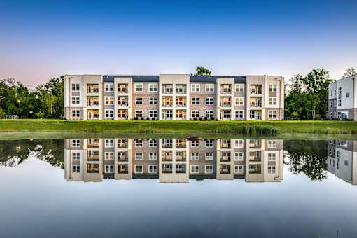A building is reflected in the water in front of it.