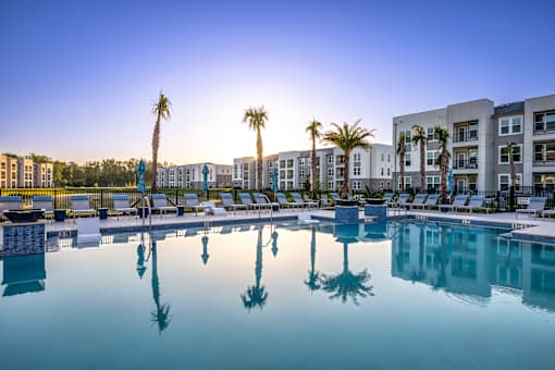 A pool with palm trees reflected in the water.