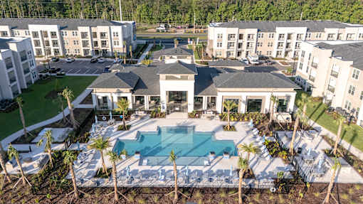 A large white building with a pool in front.