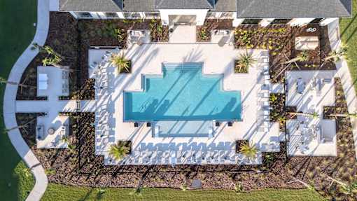 An aerial view of a house with a swimming pool in the backyard.