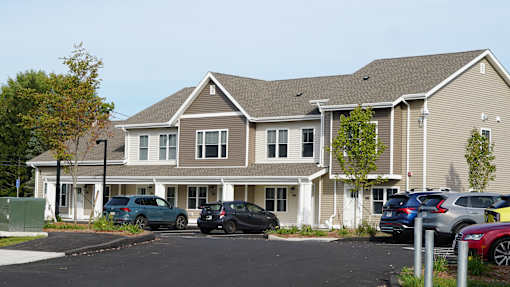 A large two-story building with a parking lot in front.