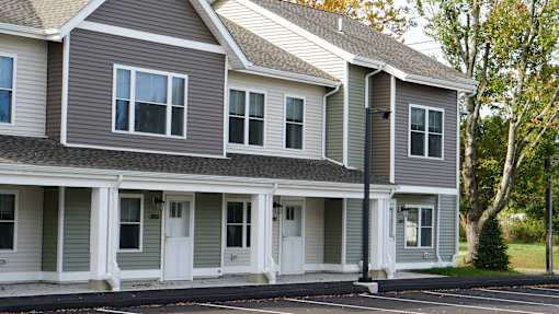 A grey house with white trim and a black roof.