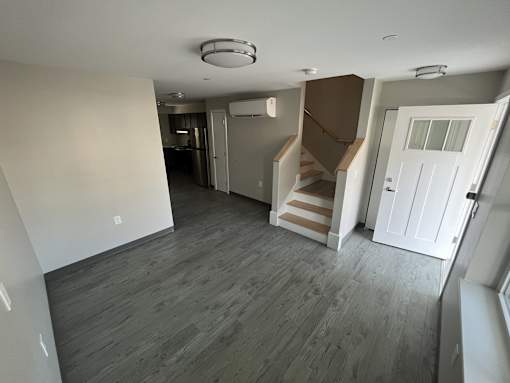 A room with a staircase and a white door.