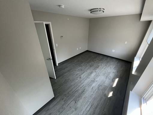 A room with a grey floor and a white door.