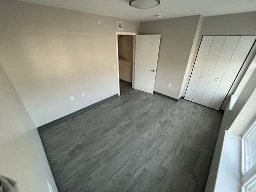 A room with a grey floor and a white door.
