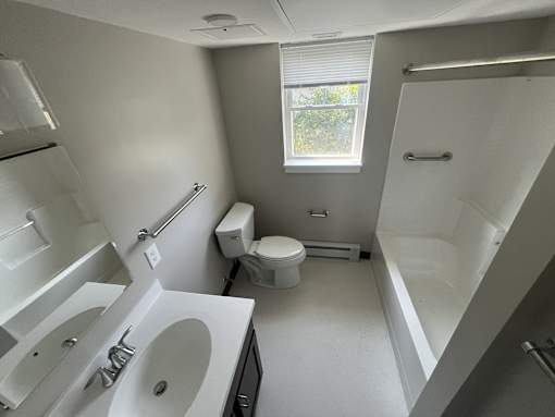 A white bathroom with a toilet, sink, and bathtub.