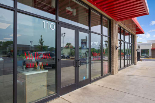 a store front with glass windows and a red awning